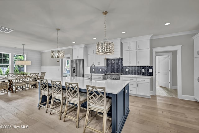 612 Waterstone Dr, Wilmington, NC 28411 - kitchen with stainless steel refrigerator with ice dispenser, a chandelier, light countertops, stove, and white cabinetry