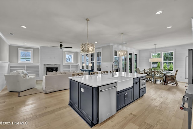 612 Waterstone Dr, Wilmington, NC 28411 - kitchen with stainless steel dishwasher, light countertops, a chandelier, light wood finished floors, and ornamental molding