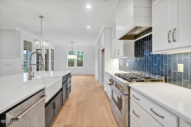 kitchen featuring stainless steel appliances, decorative light fixtures, custom exhaust hood, white cabinetry, and light hardwood / wood-style floors