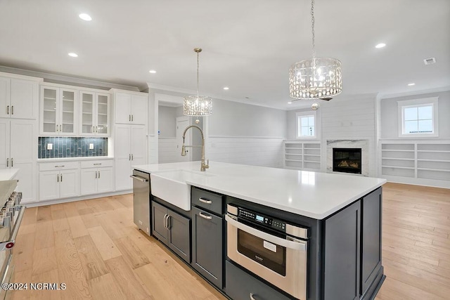 612 Waterstone Dr, Wilmington, NC 28411 - kitchen with a chandelier, white cabinetry, light wood-style floors, appliances with stainless steel finishes, and crown molding