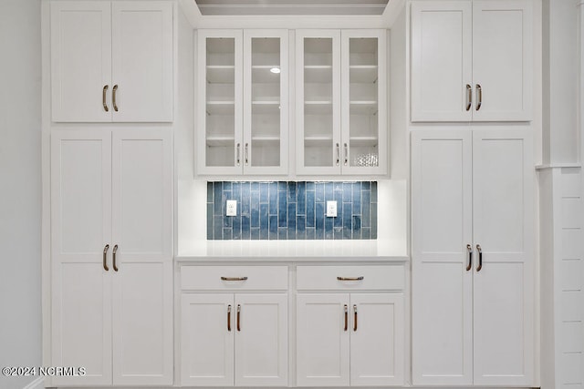 kitchen featuring white cabinets and backsplash