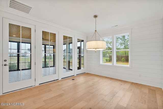 interior space with french doors, wooden walls, and wood-type flooring