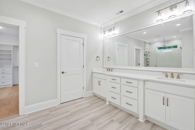 bathroom featuring a shower with door, ornamental molding, vanity, and wood-type flooring