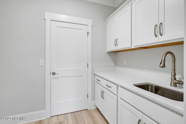 kitchen featuring white cabinetry, light hardwood / wood-style flooring, and sink