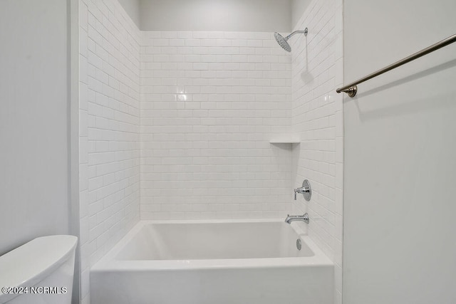 bathroom with toilet and tiled shower / bath combo