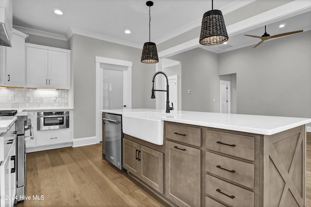 kitchen featuring white cabinetry, sink, pendant lighting, a center island with sink, and appliances with stainless steel finishes