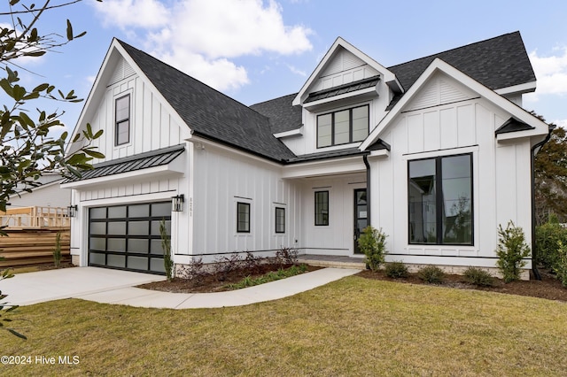 modern farmhouse with board and batten siding, a front yard, a standing seam roof, and metal roof