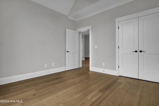 unfurnished bedroom with vaulted ceiling, light wood-type flooring, and a closet