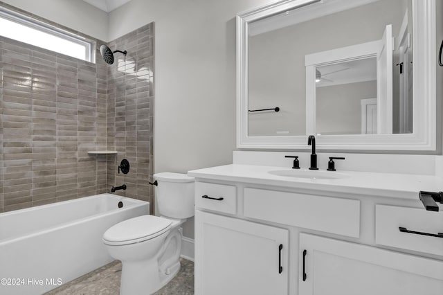 full bathroom featuring ceiling fan, vanity, tiled shower / bath combo, and toilet