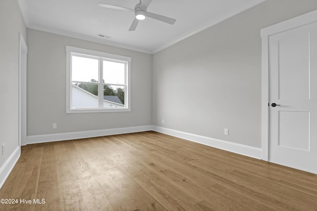 empty room featuring ceiling fan, light hardwood / wood-style floors, and ornamental molding