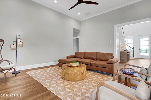 living room featuring light hardwood / wood-style floors, crown molding, and ceiling fan