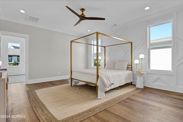 bedroom featuring ornamental molding, wood-type flooring, and ceiling fan