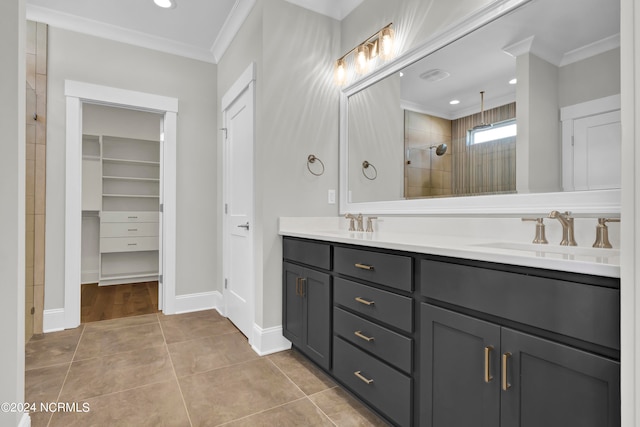 bathroom featuring a tile shower, ornamental molding, vanity, and tile patterned floors