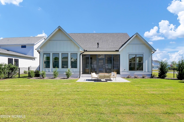 back of house featuring a patio, a sunroom, and a lawn