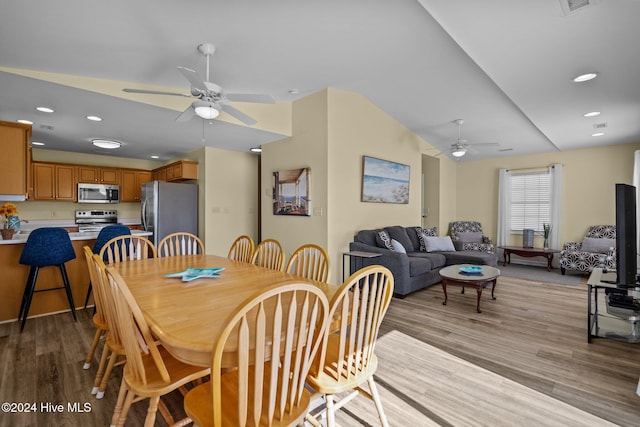 dining room with light hardwood / wood-style flooring, lofted ceiling, and ceiling fan