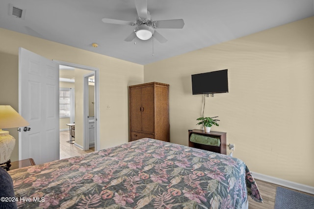 bedroom featuring light hardwood / wood-style floors, ensuite bath, and ceiling fan