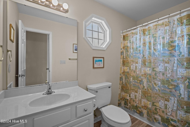 bathroom with vanity, toilet, a shower with shower curtain, and hardwood / wood-style floors