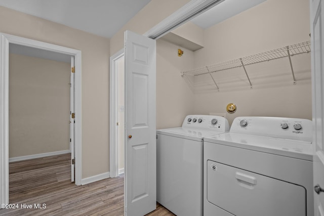 washroom with washing machine and dryer and light wood-type flooring