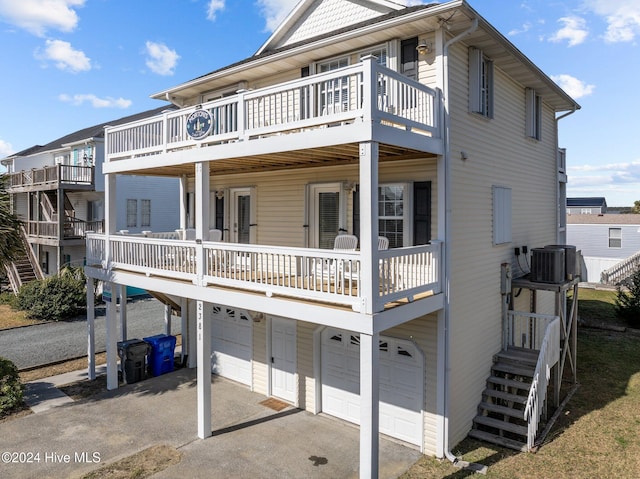 view of front of home with central air condition unit, a wooden deck, and a garage