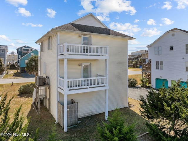 back of house with central AC unit and a balcony