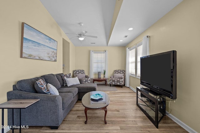 living room featuring light hardwood / wood-style flooring and ceiling fan