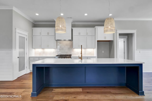 kitchen featuring a large island, hardwood / wood-style floors, white cabinetry, and pendant lighting