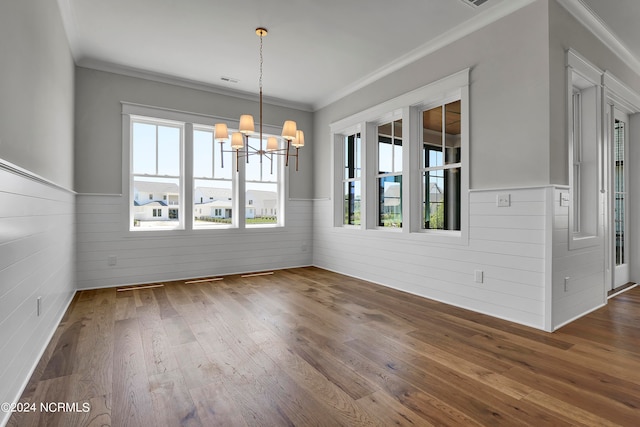 unfurnished dining area with ornamental molding, dark hardwood / wood-style floors, and an inviting chandelier