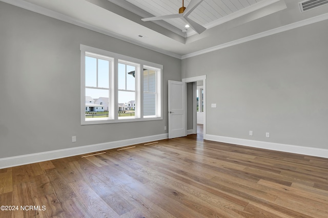 spare room featuring light hardwood / wood-style floors, crown molding, a tray ceiling, and ceiling fan