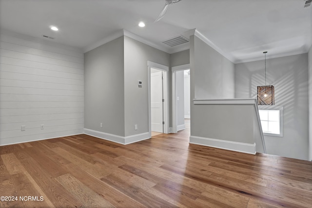 empty room with crown molding and hardwood / wood-style flooring