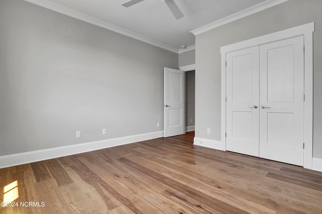 unfurnished bedroom with crown molding, a closet, light wood-type flooring, and ceiling fan