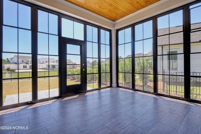 unfurnished sunroom featuring a wealth of natural light and wooden ceiling