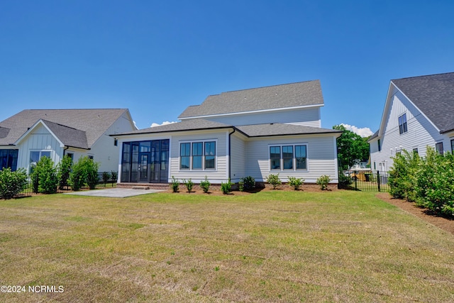 back of house with a yard, a sunroom, and a patio area