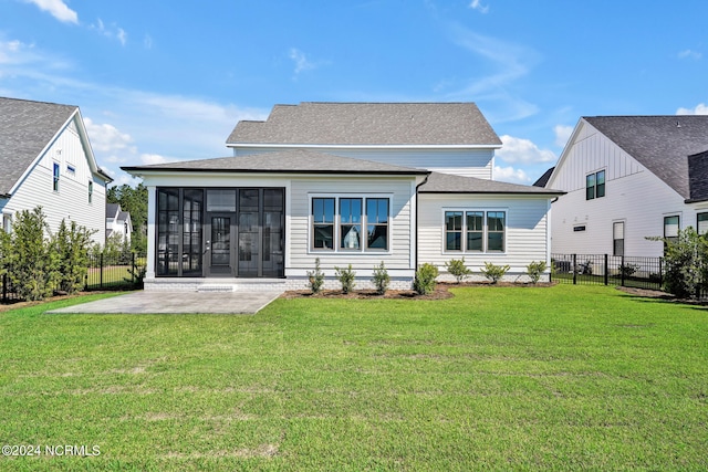 back of house with a yard, a sunroom, and a patio