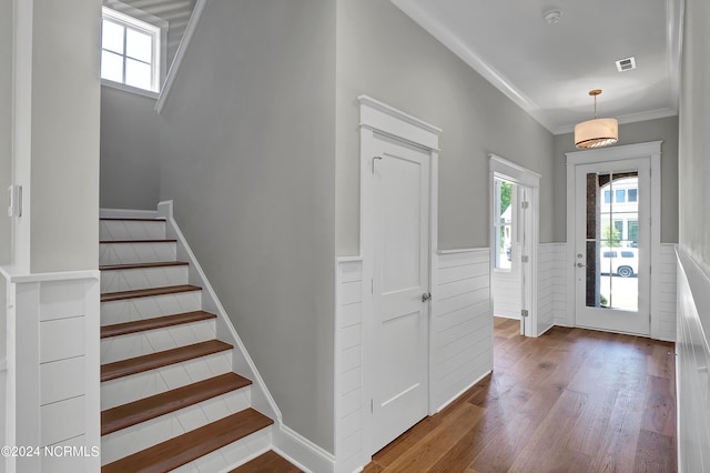 entrance foyer with ornamental molding and hardwood / wood-style floors