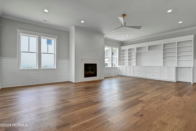 unfurnished living room with hardwood / wood-style floors, ceiling fan, a large fireplace, and plenty of natural light