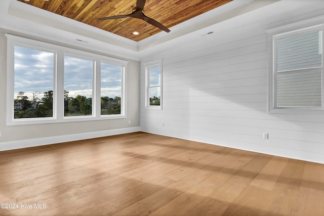 unfurnished room featuring light hardwood / wood-style floors, wood ceiling, ceiling fan, and a raised ceiling