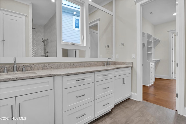 bathroom featuring a tile shower, hardwood / wood-style floors, and vanity