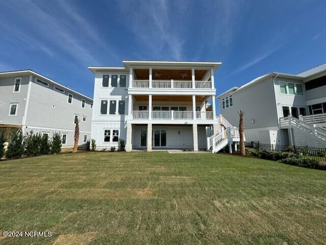 back of property featuring a balcony and a yard