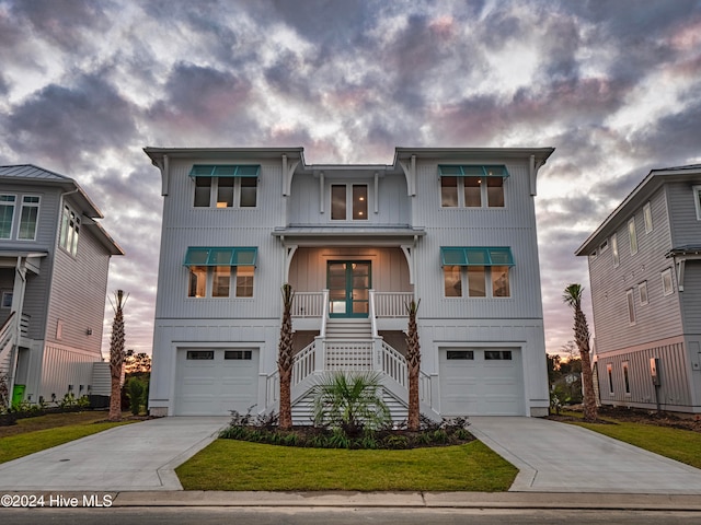 view of front facade featuring a porch, a front lawn, and a garage