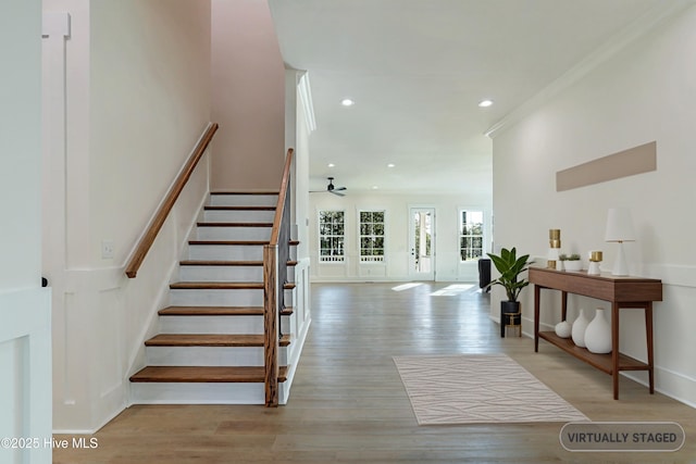 stairway with wood finished floors, recessed lighting, ceiling fan, and crown molding