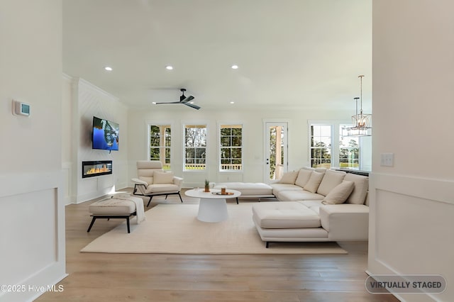 living area with wood finished floors, a fireplace, recessed lighting, and a healthy amount of sunlight