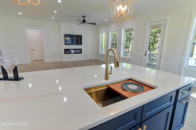 kitchen featuring white cabinetry, plenty of natural light, wall chimney range hood, and light hardwood / wood-style flooring