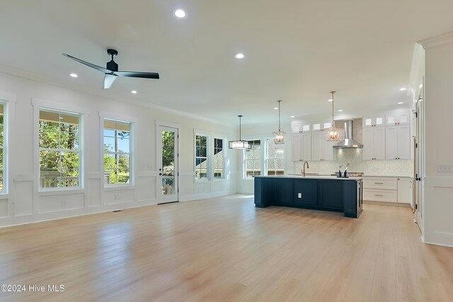 kitchen with pendant lighting, sink, light hardwood / wood-style floors, and plenty of natural light