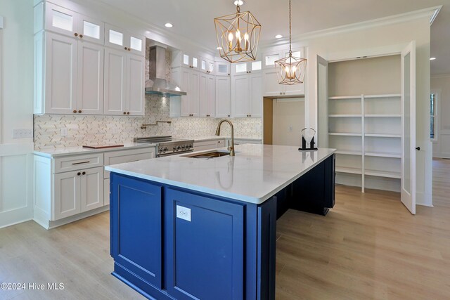 kitchen with wall chimney exhaust hood, stainless steel stove, and white cabinetry