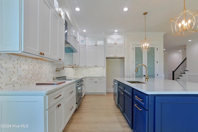 kitchen featuring sink, appliances with stainless steel finishes, hanging light fixtures, ventilation hood, and white cabinets