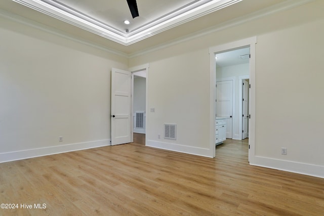 spare room featuring light wood-style floors, visible vents, and baseboards
