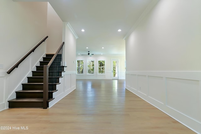 empty room with ceiling fan and light hardwood / wood-style flooring