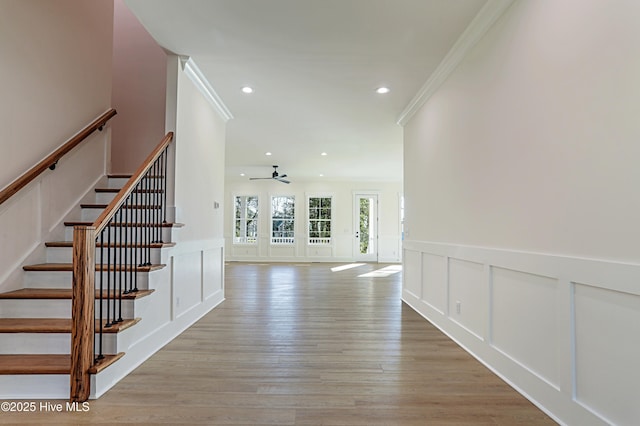 interior space featuring ceiling fan, a decorative wall, crown molding, and recessed lighting