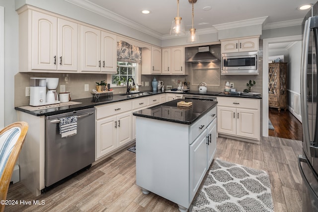 kitchen featuring appliances with stainless steel finishes, sink, a kitchen island, light hardwood / wood-style floors, and wall chimney exhaust hood