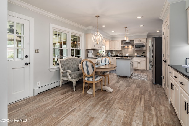 kitchen with a baseboard heating unit, light hardwood / wood-style floors, stainless steel appliances, decorative light fixtures, and crown molding